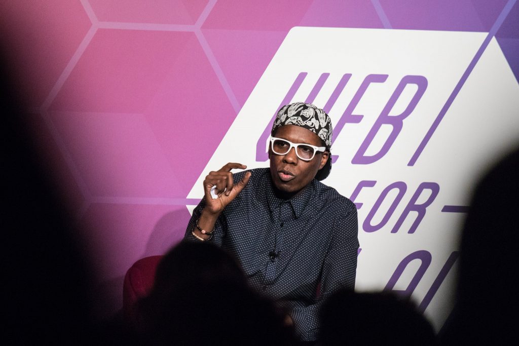 Man in sunglasses seated during a panel discussion