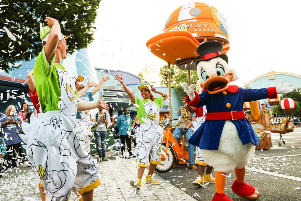 Street parade with dancers and a large costumed character