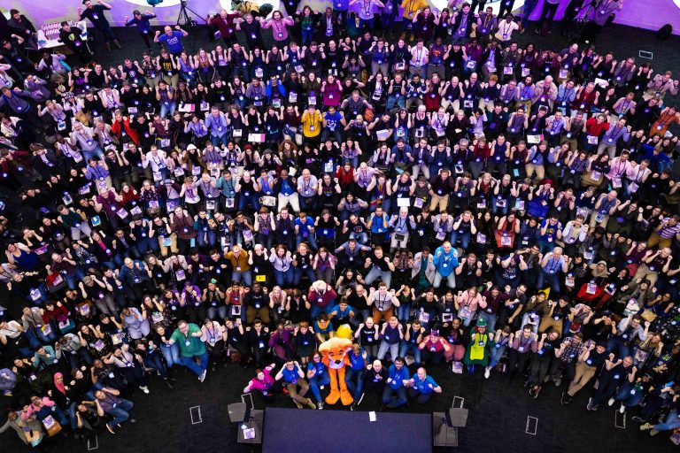 Overhead view of a large conference group gathered around a stage