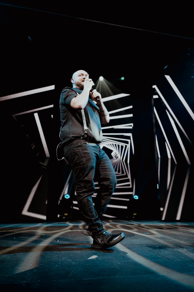 Singer performing on a dark stage