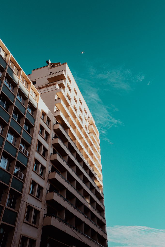 Tall apartment building against a turquoise sky