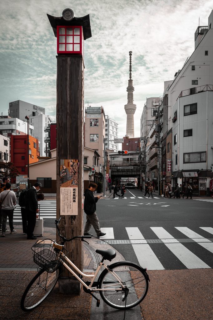 Bicycle beside a busy city crossing and red kiosk
