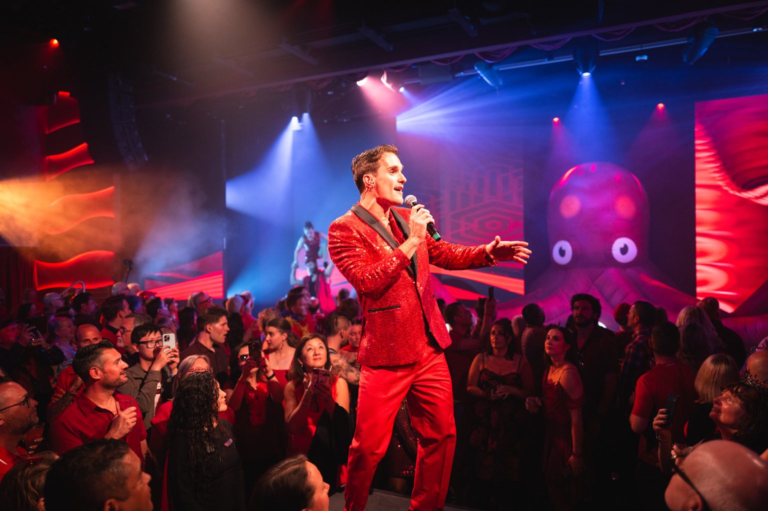Singer in a red suit performing among the audience