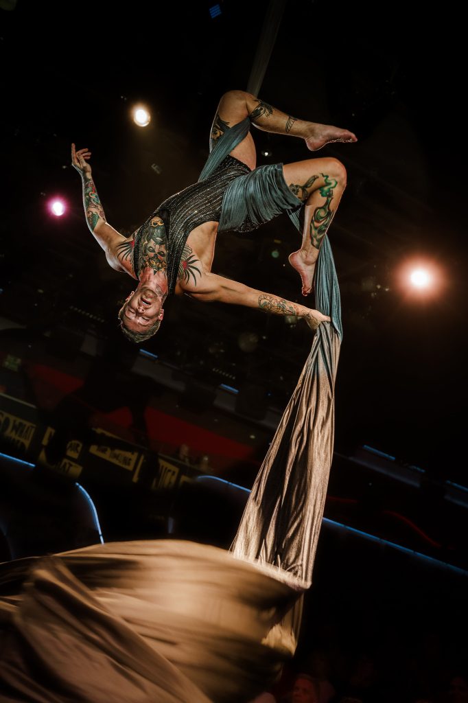Aerialist performing upside down above the stage