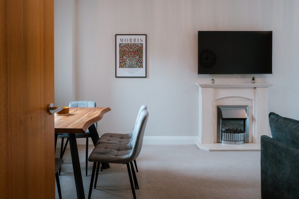 Dining area and fireplace seen through an open wooden door