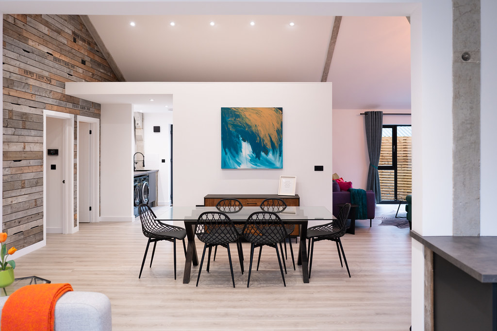 Open-plan dining area with exposed brick and colourful artwork