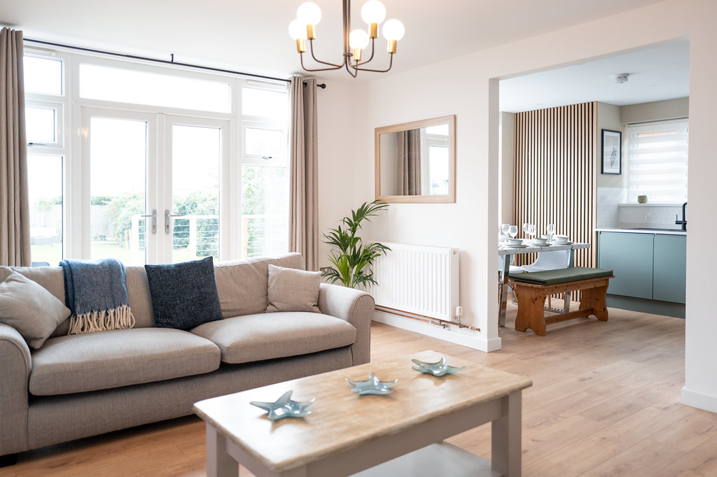 Bright lounge with a grey sofa and step-free route to the kitchen