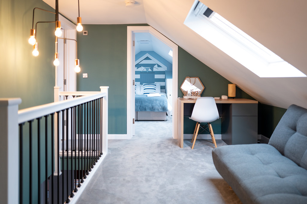Attic landing with a desk, sofa and roof window