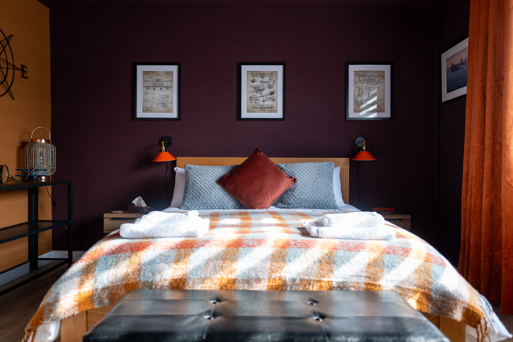 Bedroom with a plum feature wall and patterned bedding