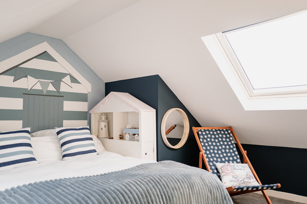 Nautical-themed twin bedroom beneath a sloping ceiling