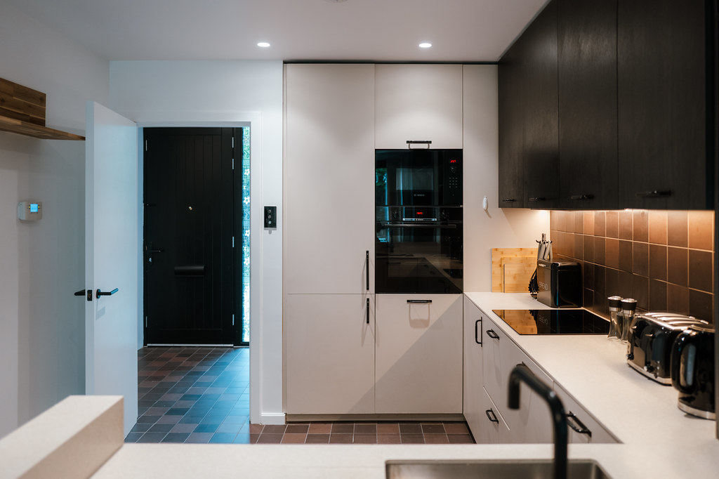 Modern black-and-white kitchen viewed towards the entrance