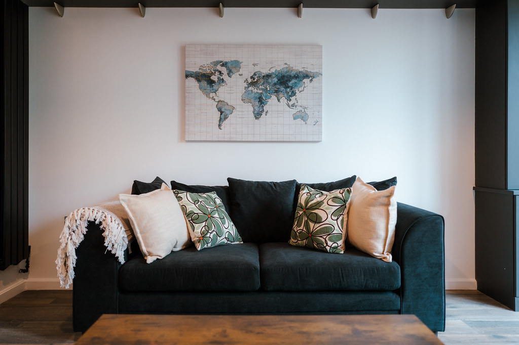 Living room with a deep green sofa and map artwork