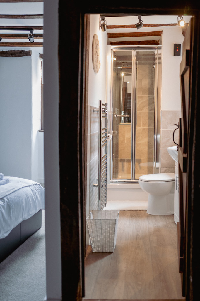 Narrow timber-framed hallway between a bedroom and bathroom