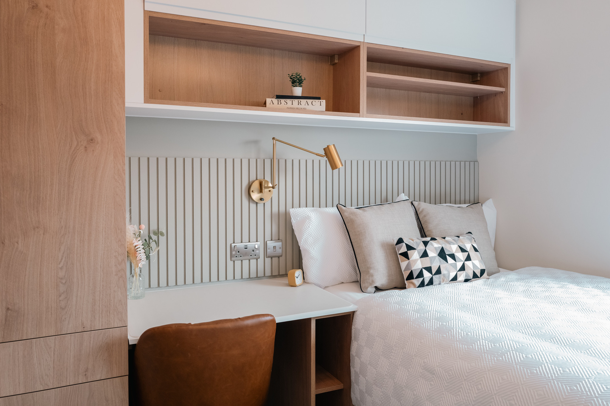 Bedroom with integrated desk, timber storage and neutral panelling
