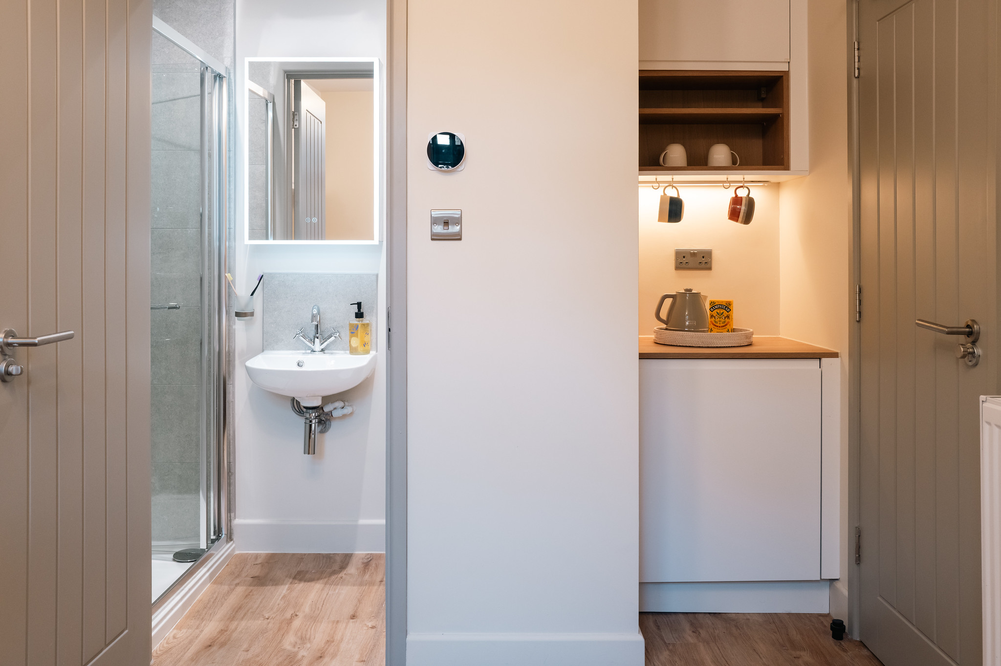 Compact ensuite shower and refreshment station between two doorways